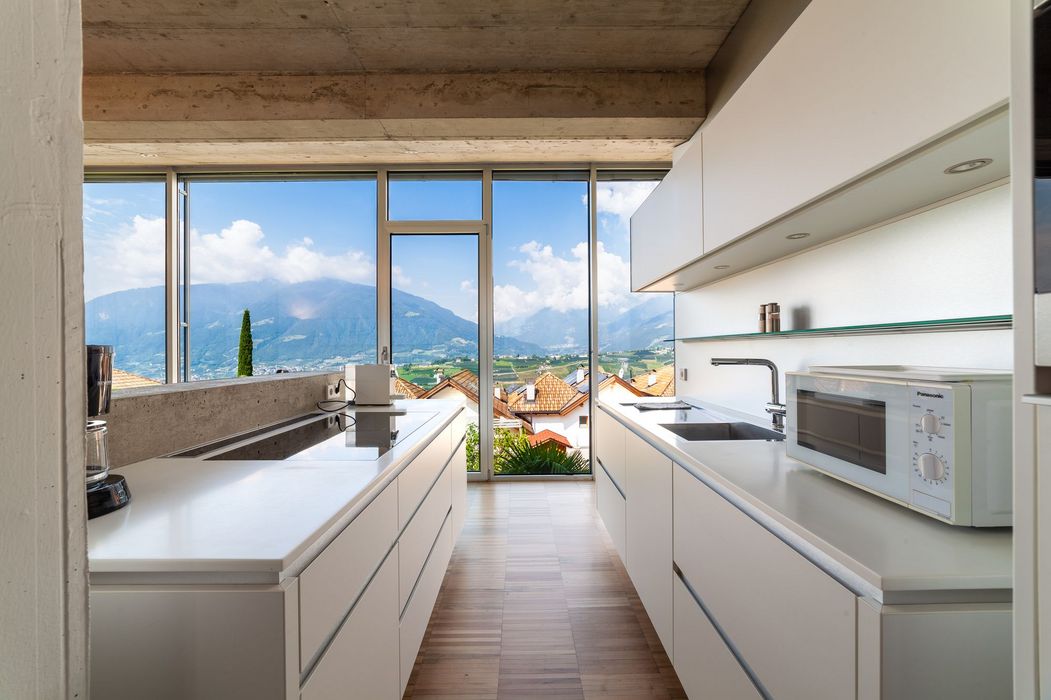 Helle moderne Küche mit großer Fensterfront und weitem Bergblick