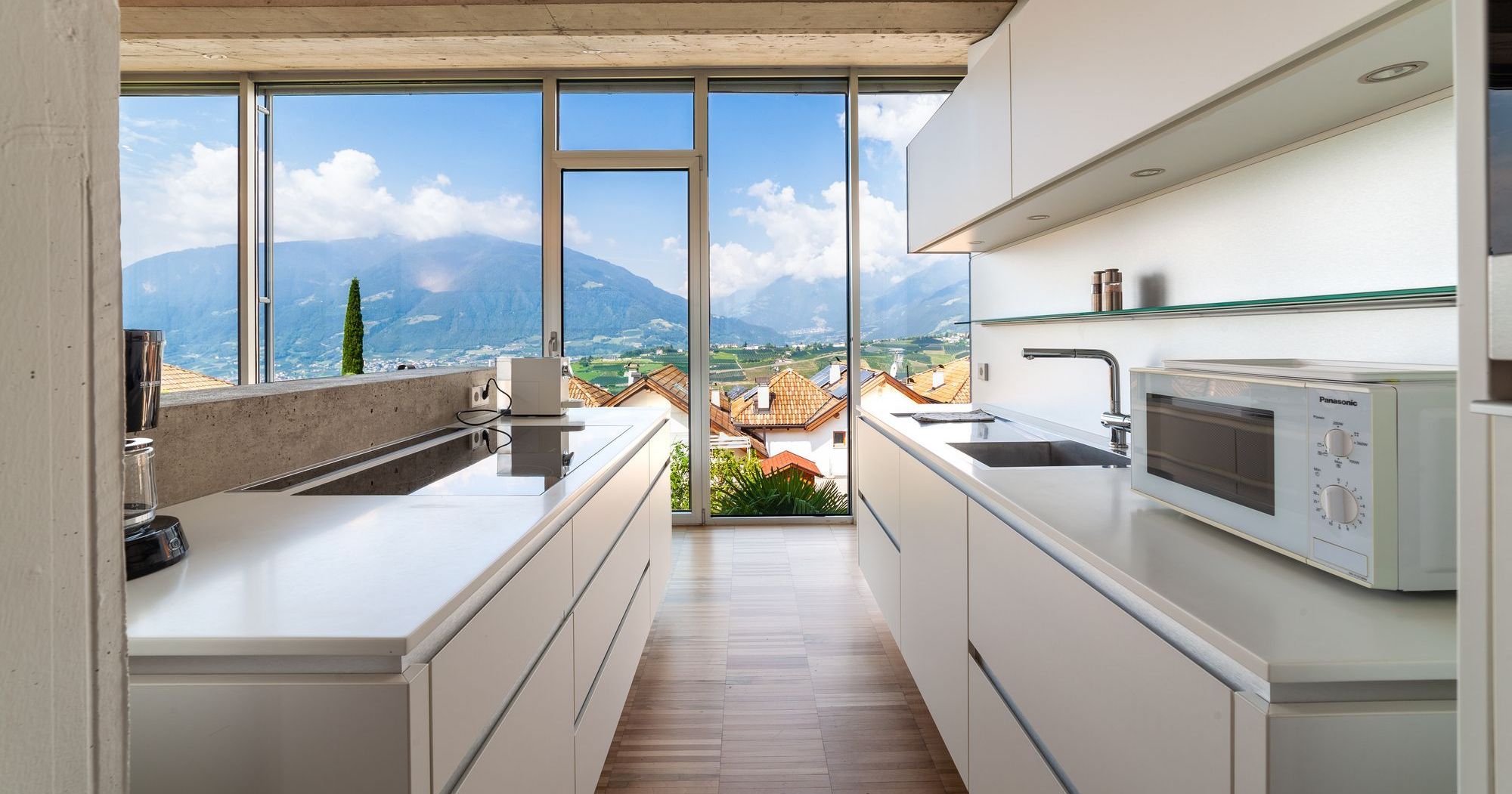 Helle moderne Küche mit großer Fensterfront und weitem Bergblick