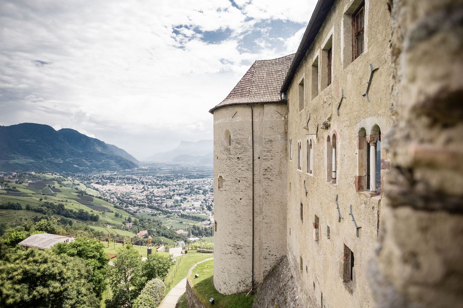 Burgmauer mit rundem Turm, Blick auf Tal, Stadt und Berge